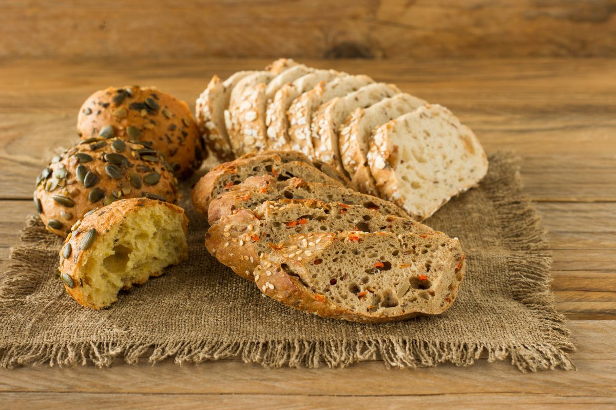 DIfferent varieties of sliced breads on a wooden table.