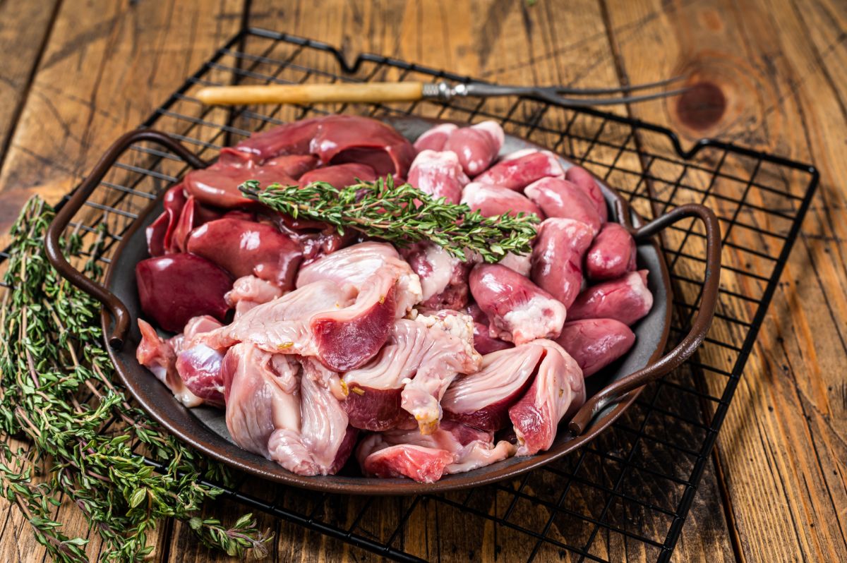 Meat byproducts with herbs on a pan on a rack.